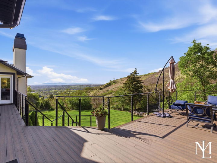 Expansive deck with hillside privacy and panoramic valley views at luxury home on Layton’s upper bench.