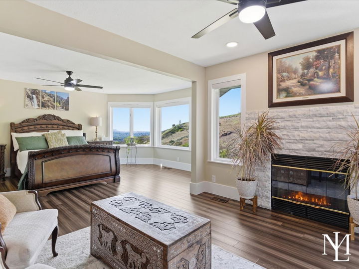 Spacious primary suite with fireplace, sitting area, and sweeping valley views in upper bench Layton home.