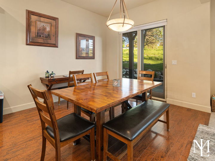 Dining area in furnished Eden mountain home with hardwood floors, sliding glass door, and access to outdoor patio