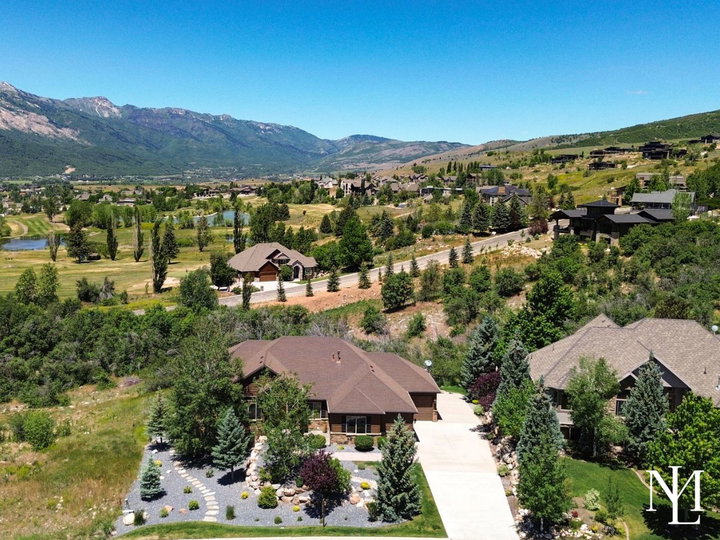 Aerial view of custom Eden Utah home near Wolf Creek Resort with mountain views and mature landscaping