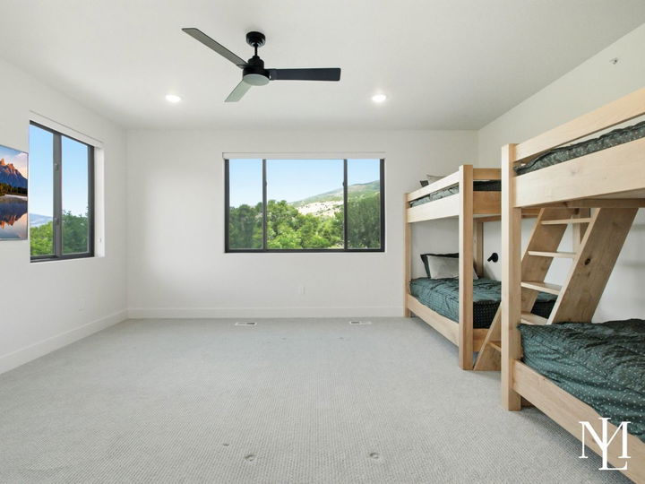 Bunk room with two wood bunk beds, large window, and mountain views.