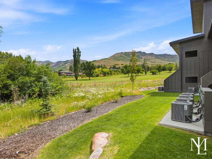 Exterior view from The Pointe at Wolf Creek with golf course, open green space, and mountain backdrop.