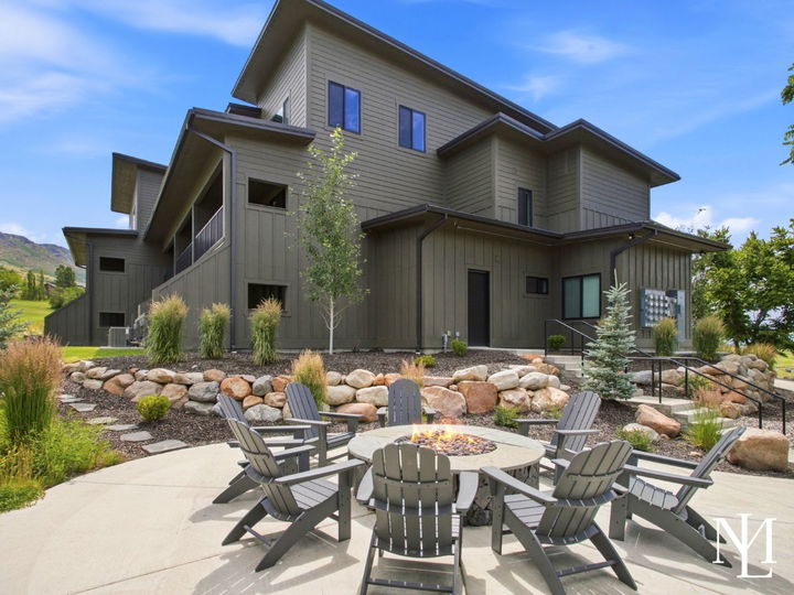 Outdoor fire pit gathering area at The Pointe at Wolf Creek with Adirondack chairs and mountain views.