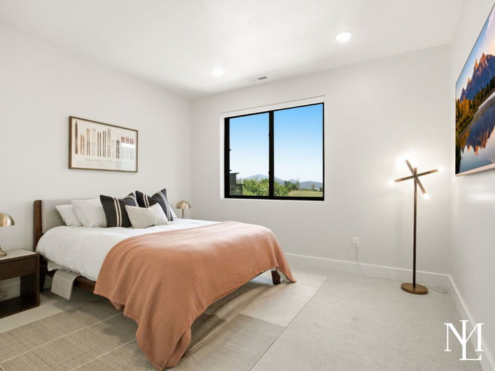 Bedroom with mountain views, neutral finishes, ski-themed decor, and warm accent bedding.