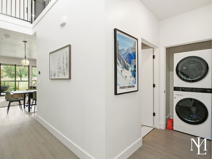 Hallway with laundry closet, Powder Mountain artwork, and open view into the dining area.