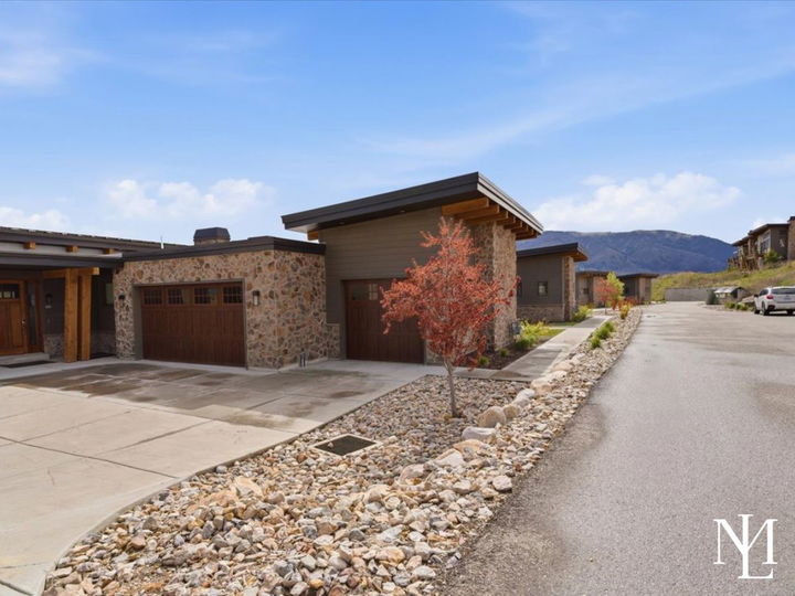 Eden, Utah townhome exterior with stone accents, garage, mountain backdrop, and landscaped entry