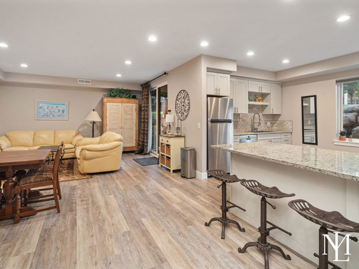 Lower-level apartment with full kitchen, breakfast bar, dining area, and living space.