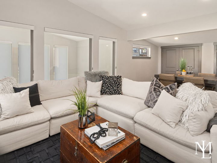 Comfortable lower-level living area with sectional sofa, dining space, and neutral finishes.