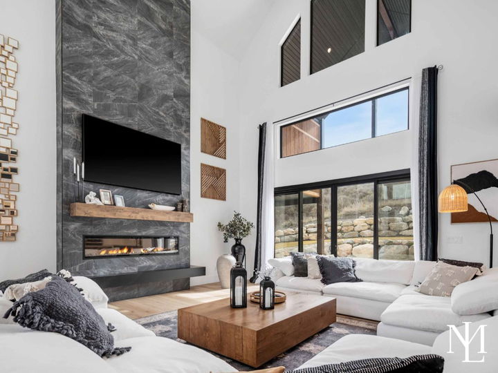 Great room with soaring ceilings, floor-to-ceiling fireplace, and large windows.