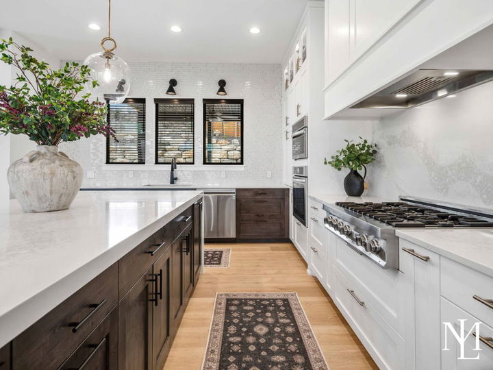 Gourmet kitchen with large quartz island, custom cabinetry, and stainless steel range.