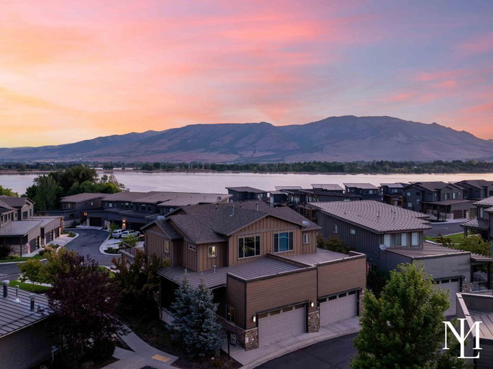 Aerial sunset view of the Huntsville townhome community near Pineview Reservoir with mountains in the distance.