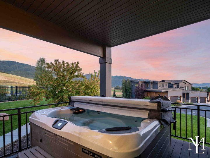 Covered deck with private hot tub overlooking the Huntsville community and sunset mountain views.