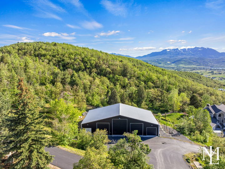 Large detached shop surrounded by trees with expansive mountain and valley views in Huntsville, Utah.