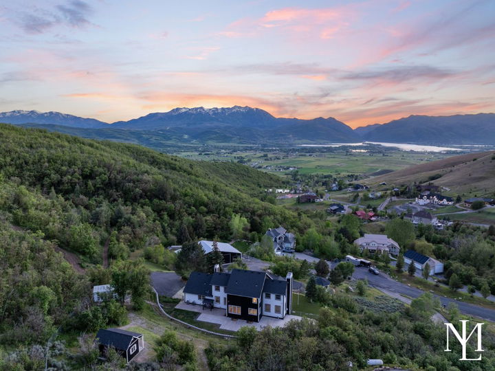 Aerial sunset view of a private Huntsville estate overlooking Ogden Valley, Pineview Reservoir, and surrounding mountains.