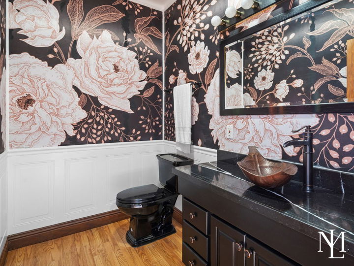 Powder bathroom with bold floral wallpaper, black vanity, vessel sink, and white wainscoting.