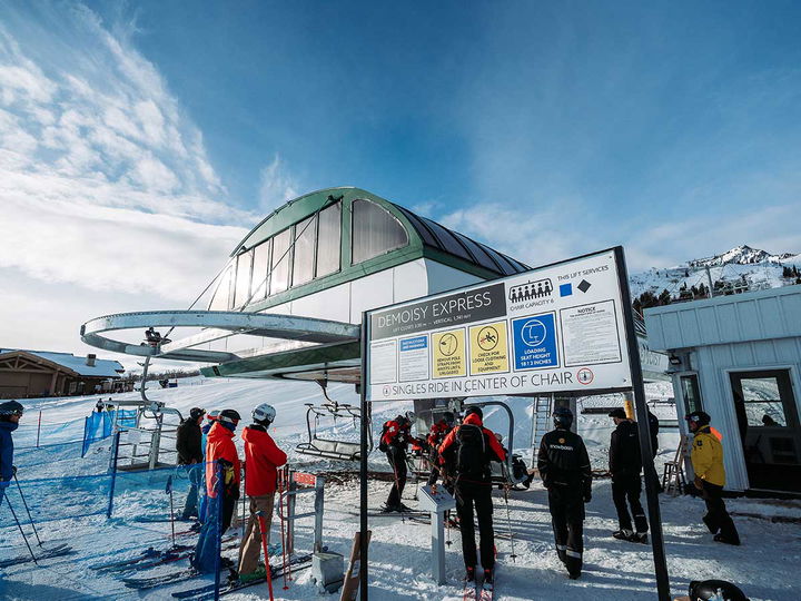 Snowbasin's Snow Patrol hops on Demoisy Express while skiers eagerly await their turn.