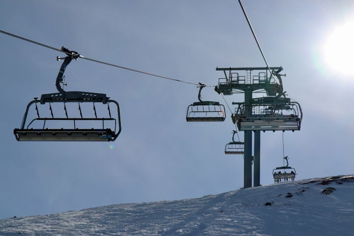 Chair lift in low-snow conditions at a ski resort.