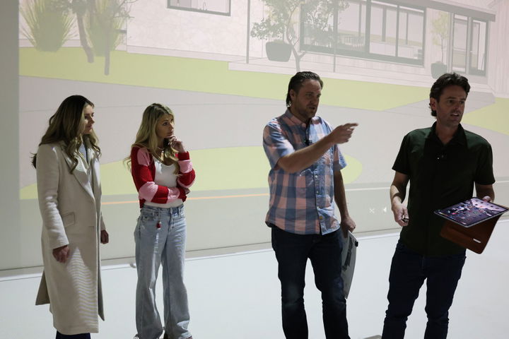 Homeowners and design team reviewing a custom home rendering during an architectural walkthrough